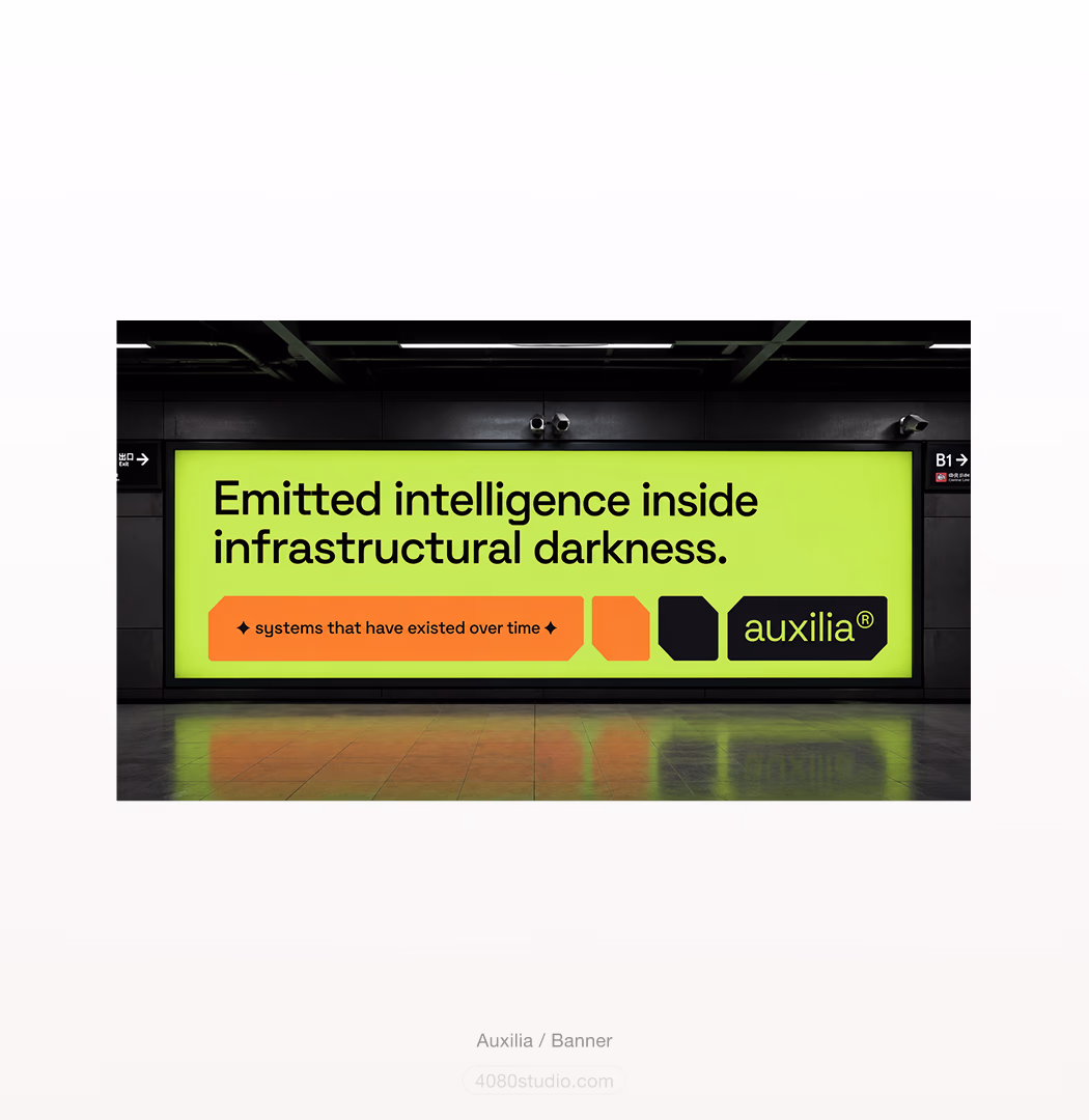 Auxilia out-of-home billboard in a subway station: an acid-lime panel reading 'Emitted intelligence inside infrastructural darkness' with an orange 'systems that have existed over time' pill and the auxilia® wordmark