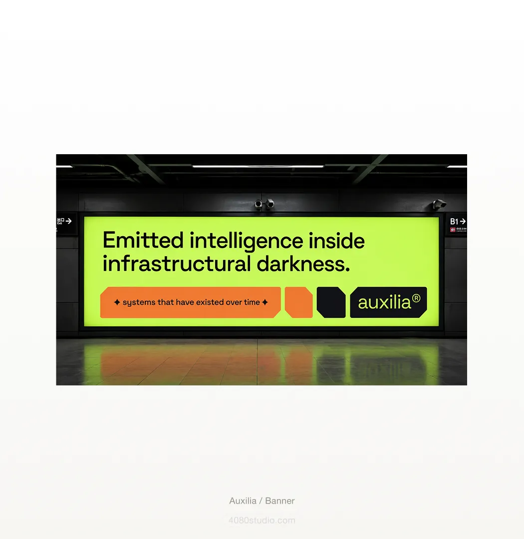 Auxilia out-of-home billboard in a subway station: an acid-lime panel reading 'Emitted intelligence inside infrastructural darkness' with an orange 'systems that have existed over time' pill and the auxilia® wordmark